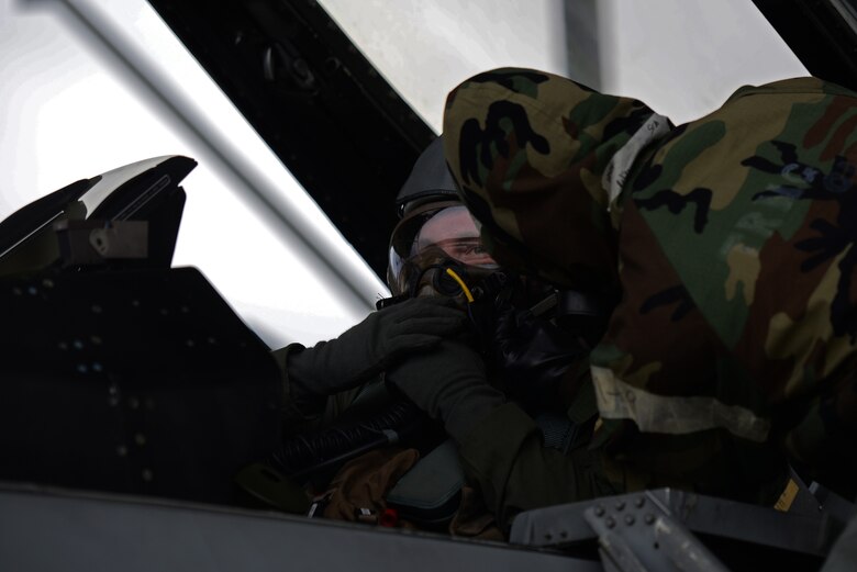 U.S. Air Force 1st Lieutenant Robert Grochalski, 79th Fighter Squadron pilot, left, and Senior Airman Delvion Wilborne, 20th Aircraft Maintenance Squadron, 79th Aircraft Maintenance Unit tactical aircraft maintainer, work together to ensure Grochalski’s mask is secure before exiting the aircraft during an exercise at Shaw Air Force Base, S.C., Dec. 7, 2017.