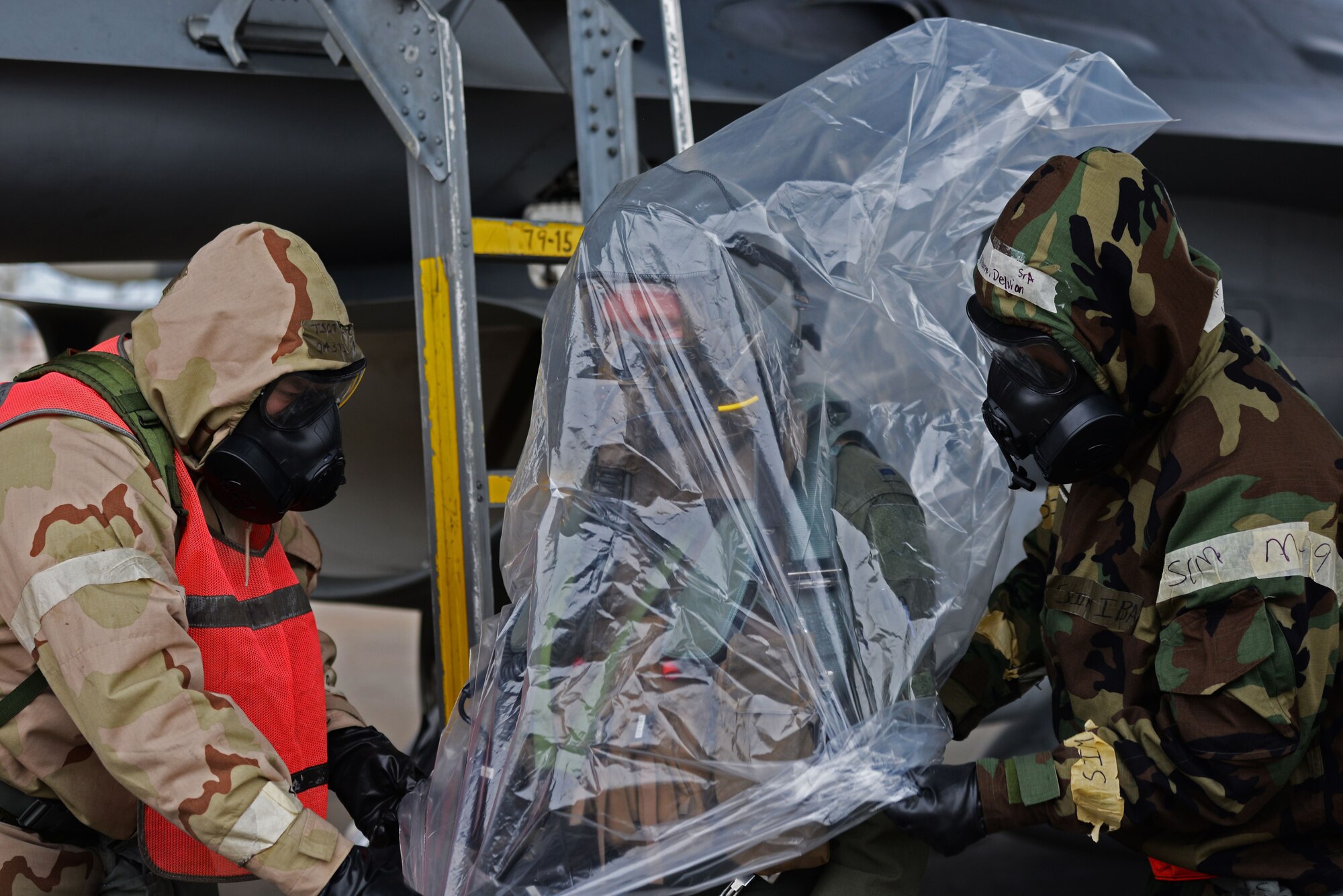 U.S. Air Force Tech. Sgt. Joseph Collett, 20th Aircraft Maintenance Squadron (AMXS), 79th Aircraft Maintenance Unit (AMU) flight line expeditor, left, and Senior Airman Delvion Wilborne, 20th AMXS, 79th AMU tactical aircraft maintainer right, ensure 1st Lieutenant Robert Grochalski, 79th Fighter Squadron pilot, center, is in full and proper mission-oriented protective posture gear during the Rapid Ready Weasel exercise at Shaw Air Force Base, S.C., Dec. 7, 2017.