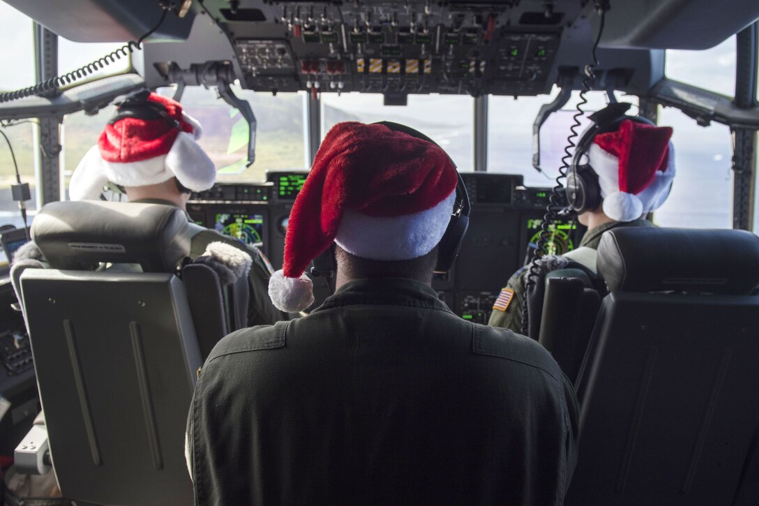 Air Force pilots and a crew chief fly a C-130J Super Hercules over Andersen Air Force Base