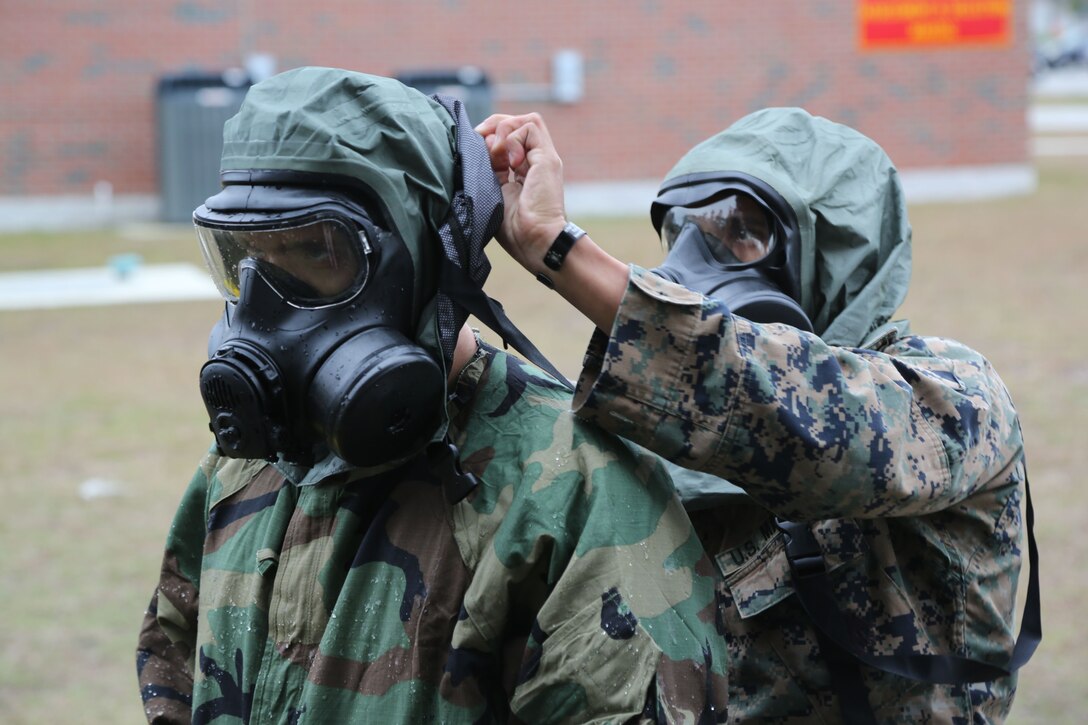 Marines and Sailors with U.S. Marine Corps Forces, Special Operations Command, demonstrate proper removal of a gas mask from a simulated chemical contact victim while training for the medical management of chemical and biological causalties during an exercise at Stone Bay on Marine Corps Base Camp Lejeune, N.C., Dec. 6, 2017. Long prohibited by international agreements, chemical weapons have been increasingly used on the battlefield by American adversaries including violent extremist organizations. Raiders gained valuable practical application skills in handling casualties in complex and dangerous chemical environments. (U.S. Marine Corps photo by Sgt. Salvador R. Moreno, released)