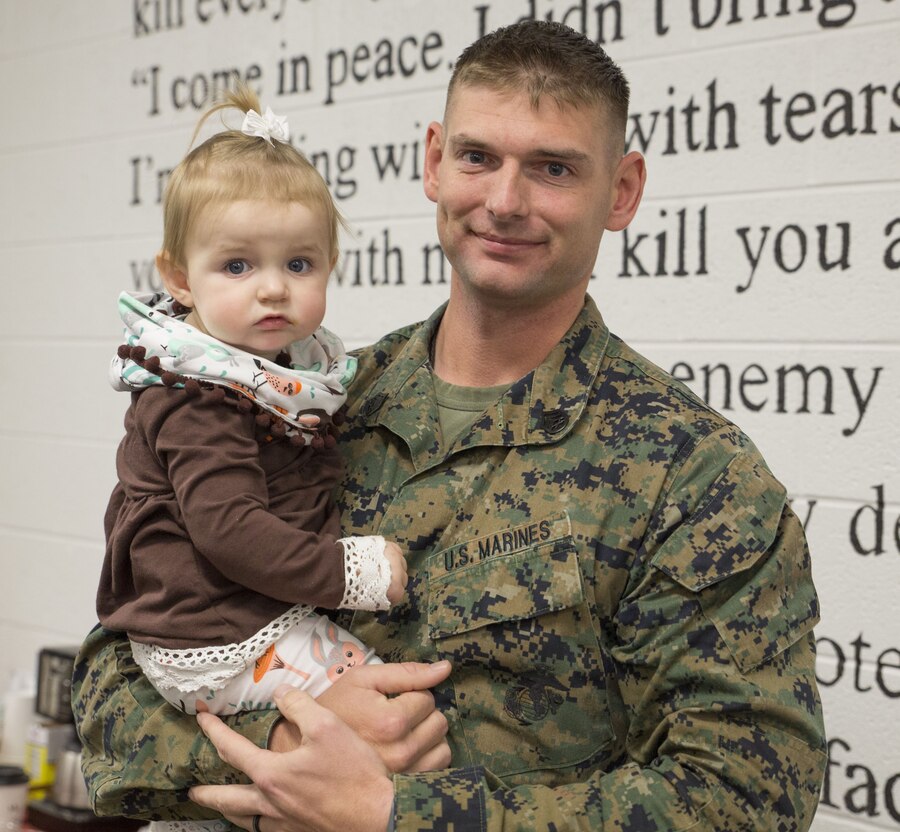 Staff Sgt. Christopher D’arcy, platoon sergeant, 2nd platoon, Charlie Co., Fleet Anti-terrorism Security Team, U.S. Marine Corps Security Forces Regiment, holds his daughter Caroline, 1, during a welcome home ceremony aboard Camp Allen, Va. Dec. 11. FAST Marines deployed for 6 months in Europe conducting security operations. (Official U.S. Marine Corps photo by Chris Jones/Released)