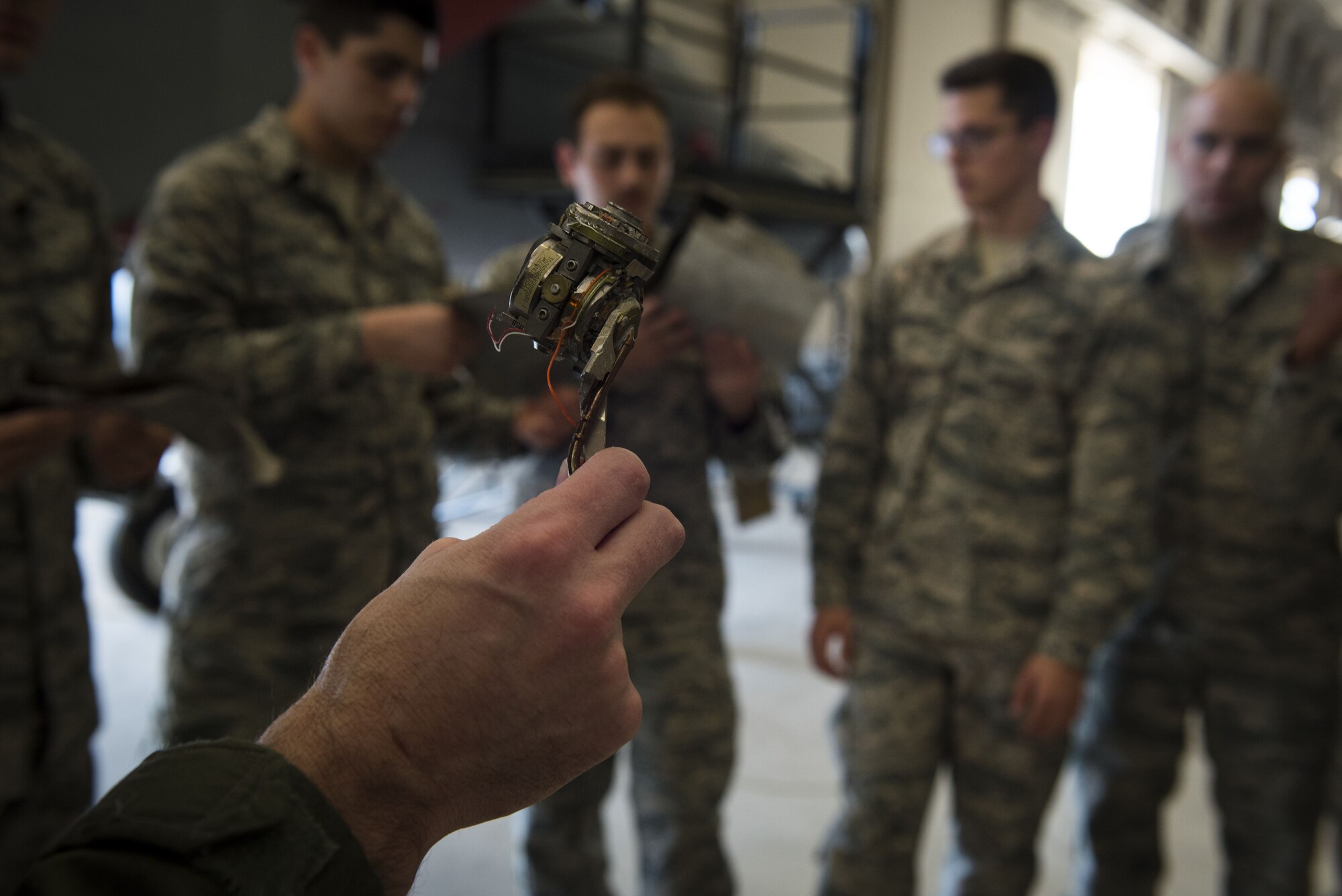 A pilot holds a piece of debris from an advanced medium-range air-to-air missile.