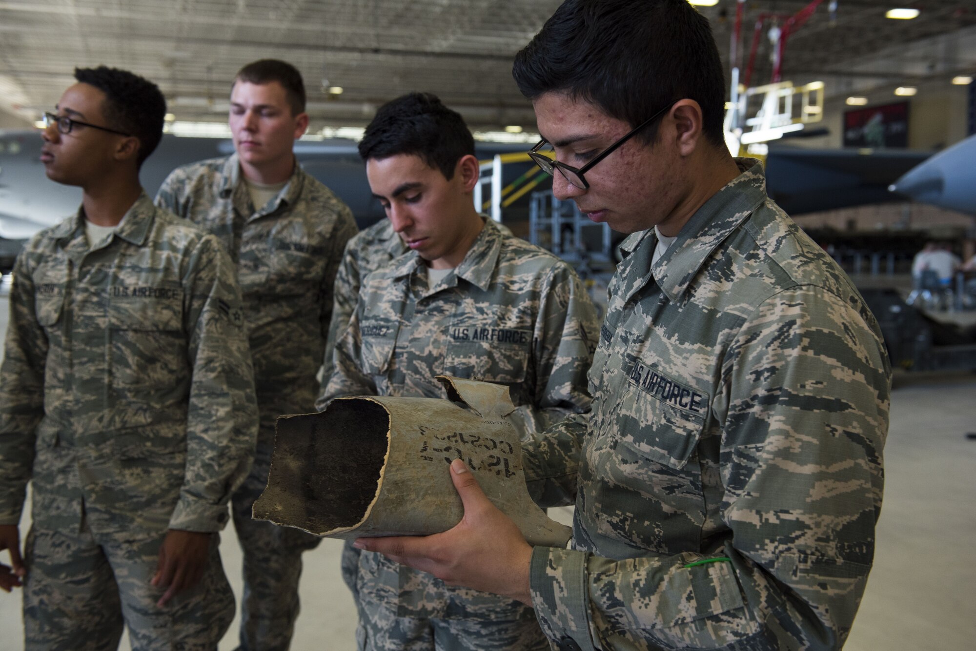 Airman holds a piece of shrapnel from an advanced medium-range air-to-air missile.
