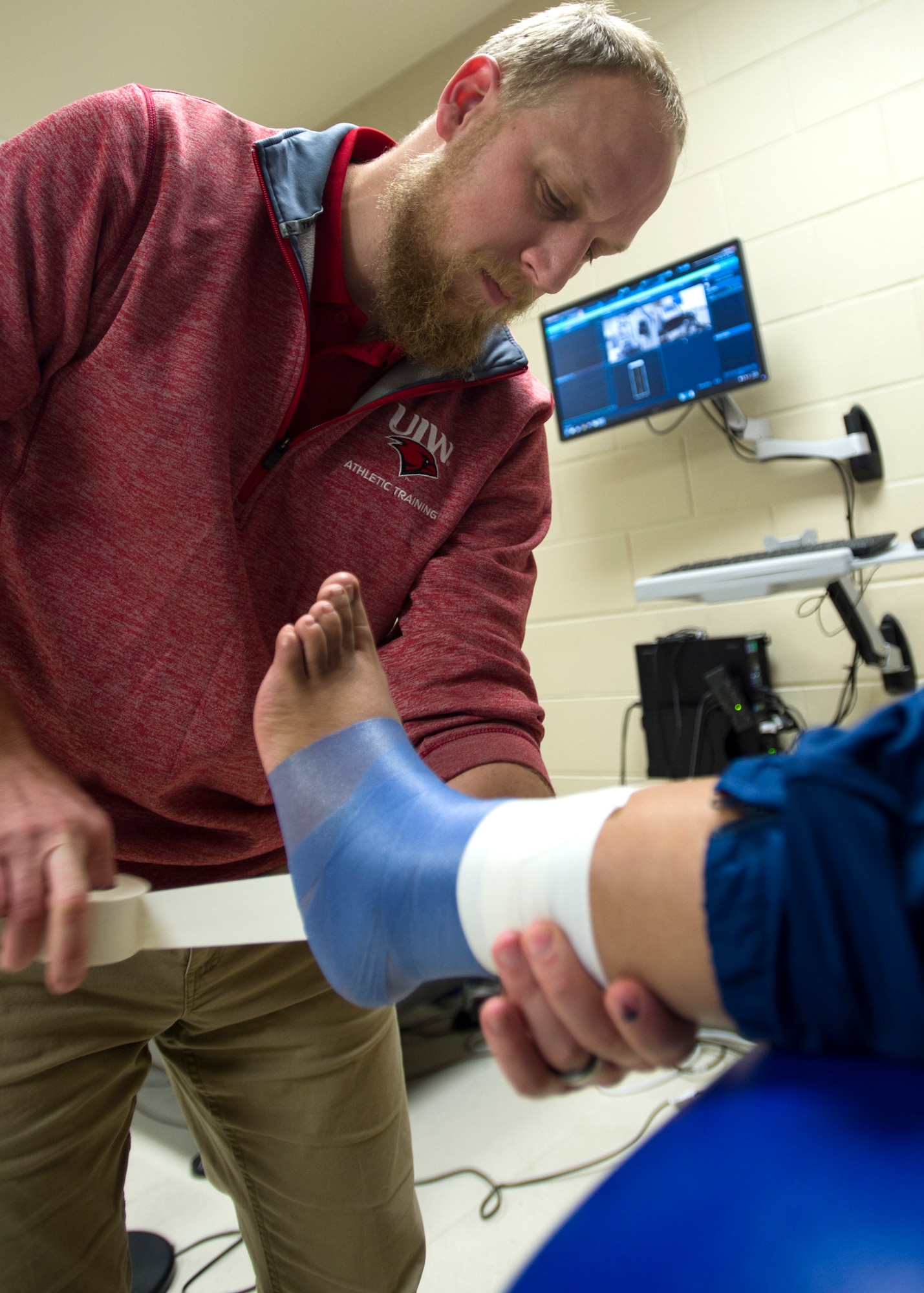 Jarod Spraggins, an athletic trainer embedded with the 323rd Training Squadron, wraps a trainee’s ankle at the 559th Medical Group VIPER Clinic on Joint Base San Antonio-Lackland, Texas, Nov. 29. The ankle taping's purpose is to provide stability on an injured ankle without having to use crutches.