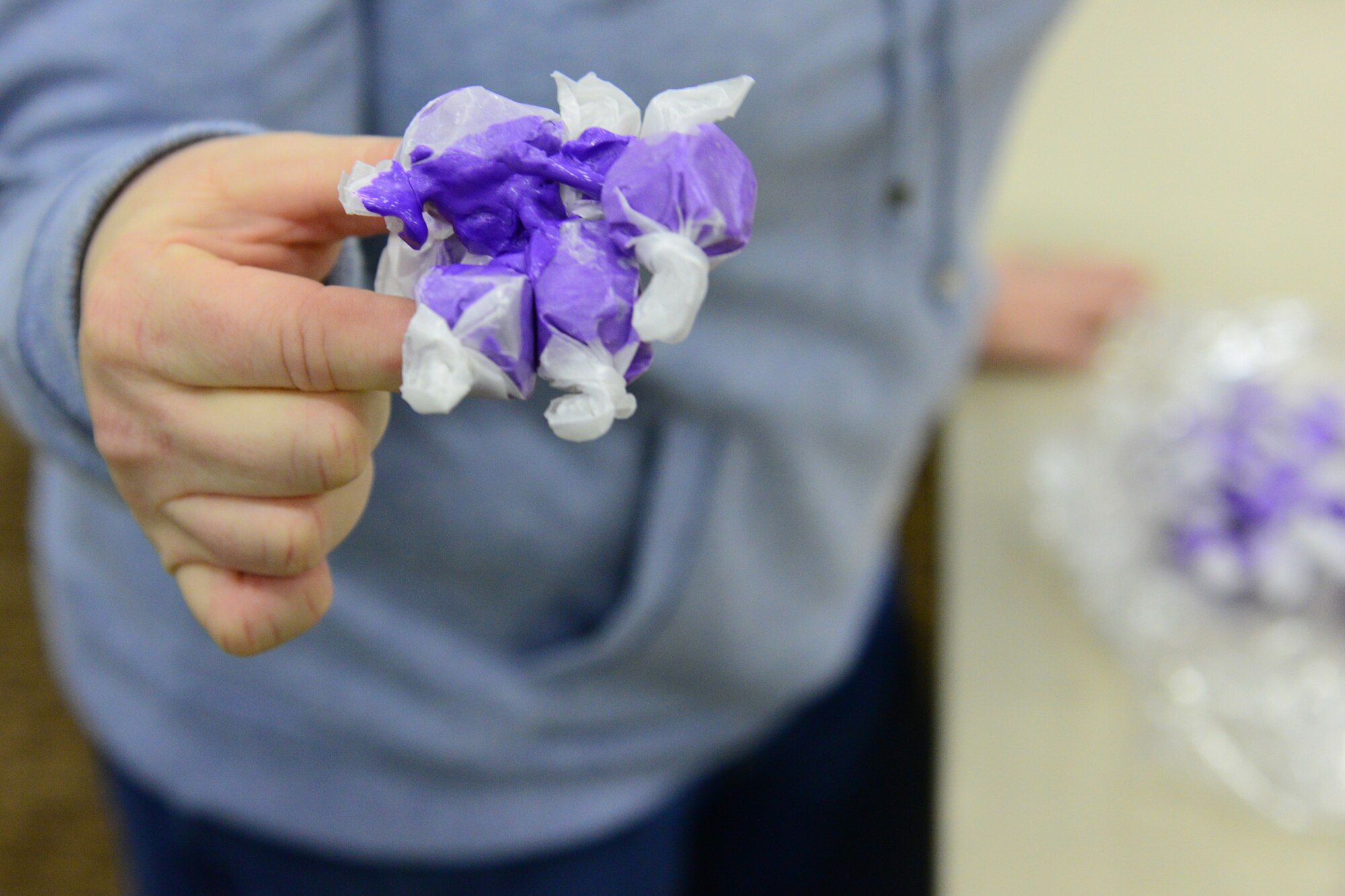 A Cookie Express volunteer holds a bundle of fused saltwater taffy Dec. 13, 2017, at Malmstrom Air Force Base, Mont.