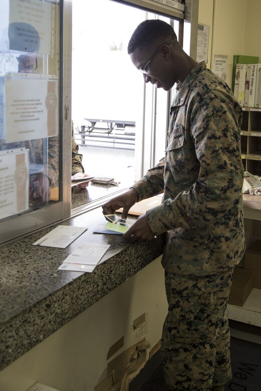 CAMP FOSTER, OKINAWA, Japan – Lance Cpl. Leroy Hubbert confirms a unit’s mail roster Dec. 12 at the Camp Foster Post Office aboard Camp Foster, Okinawa, Japan.