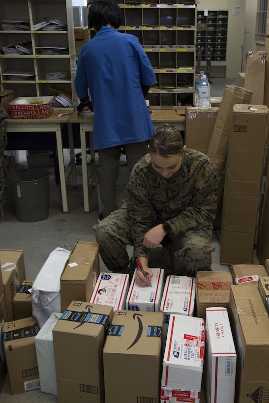 CAMP FOSTER, OKINAWA, Japan – Lance Cpl. Tiana Newton marks the unit sections on packages for Marines Dec. 12 at the Camp Foster Post Office aboard Camp Foster, Okinawa, Japan.