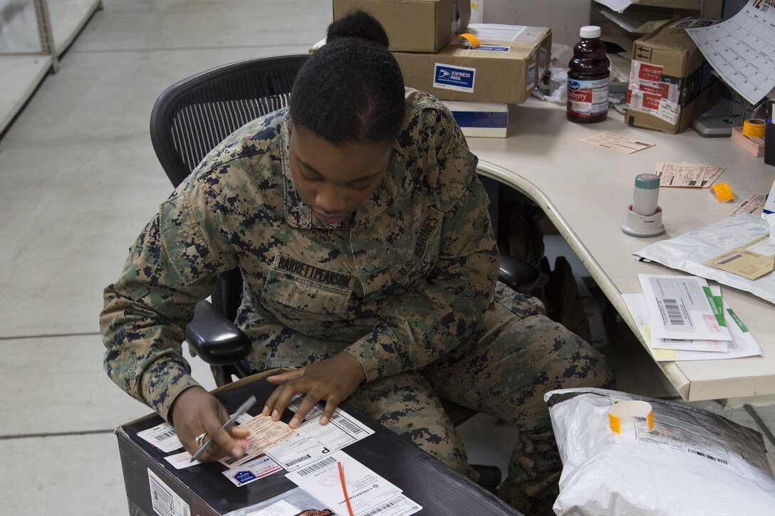 CAMP FOSTER, OKINAWA, Japan – Lance Cpl. Kishawra Barrettpearson fills out a package pick up slip for an oversized box delivered Dec. 12 at the Camp Foster Post Office aboard Camp Foster, Okinawa, Japan.