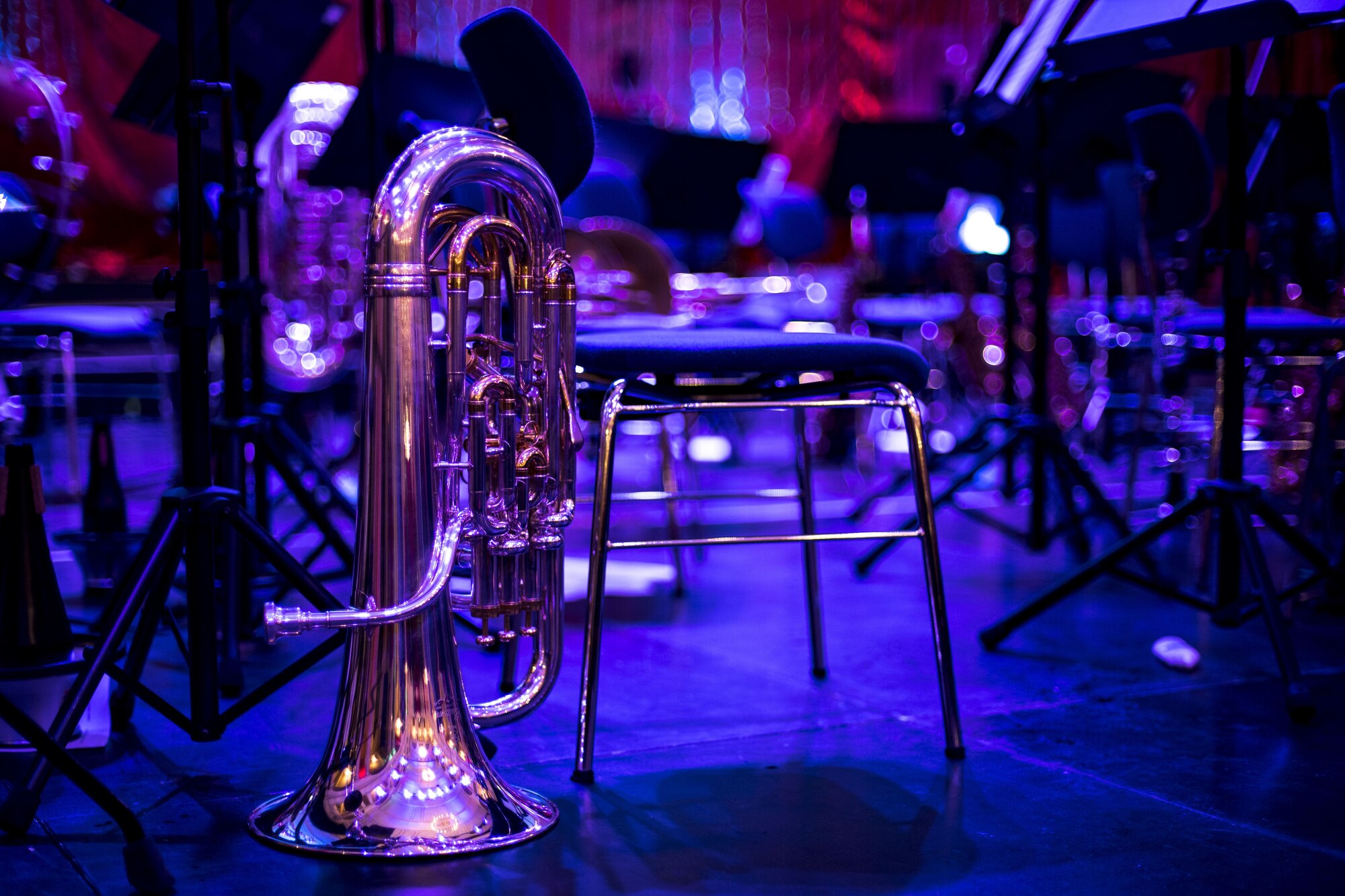 A tuba rests among United States Air Forces in Europe Band equipment on stage at Fruchthalle in Kaiserslautern, Germany, Dec. 8, 2017. Since 1943, the USAFE Band has fostered the tradition of performing live music for official military functions and community outreach events throughout the continents of Europe and Africa. (U.S. Air Force photo by Senior Airman Devin Boyer)