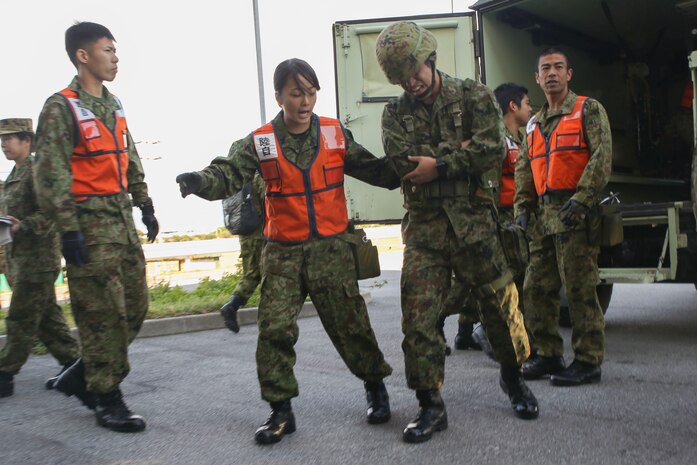 Japan Ground Self Defense Force soldiers with Medical Department, Ground Staff Office, Western Army, attend to a simulated casualty during a mass-casualty scenario Dec. 12, 2017, at Camp Naha, Okinawa, Japan. U.S. medical personnel from 3rd Medical Battalion, 3rd Marine Logistics Group, U.S. Marine Corps, U.S. Naval Hospital Okinawa and 18th Medical Group, 18th Wing Support Squadron, U.S. Air Force were invited to Camp Naha during the Japanese and U.S. Medical Expert Exchange Event training to learn more about each service’s medical training, tactics and procedures. (U.S. Marine Corps photo by Sgt. Tiffany Edwards)