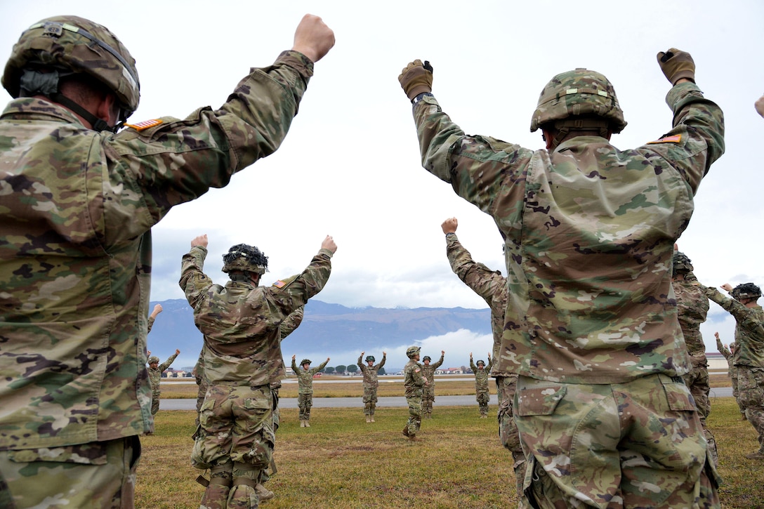 Soldiers raise their arms into the air.