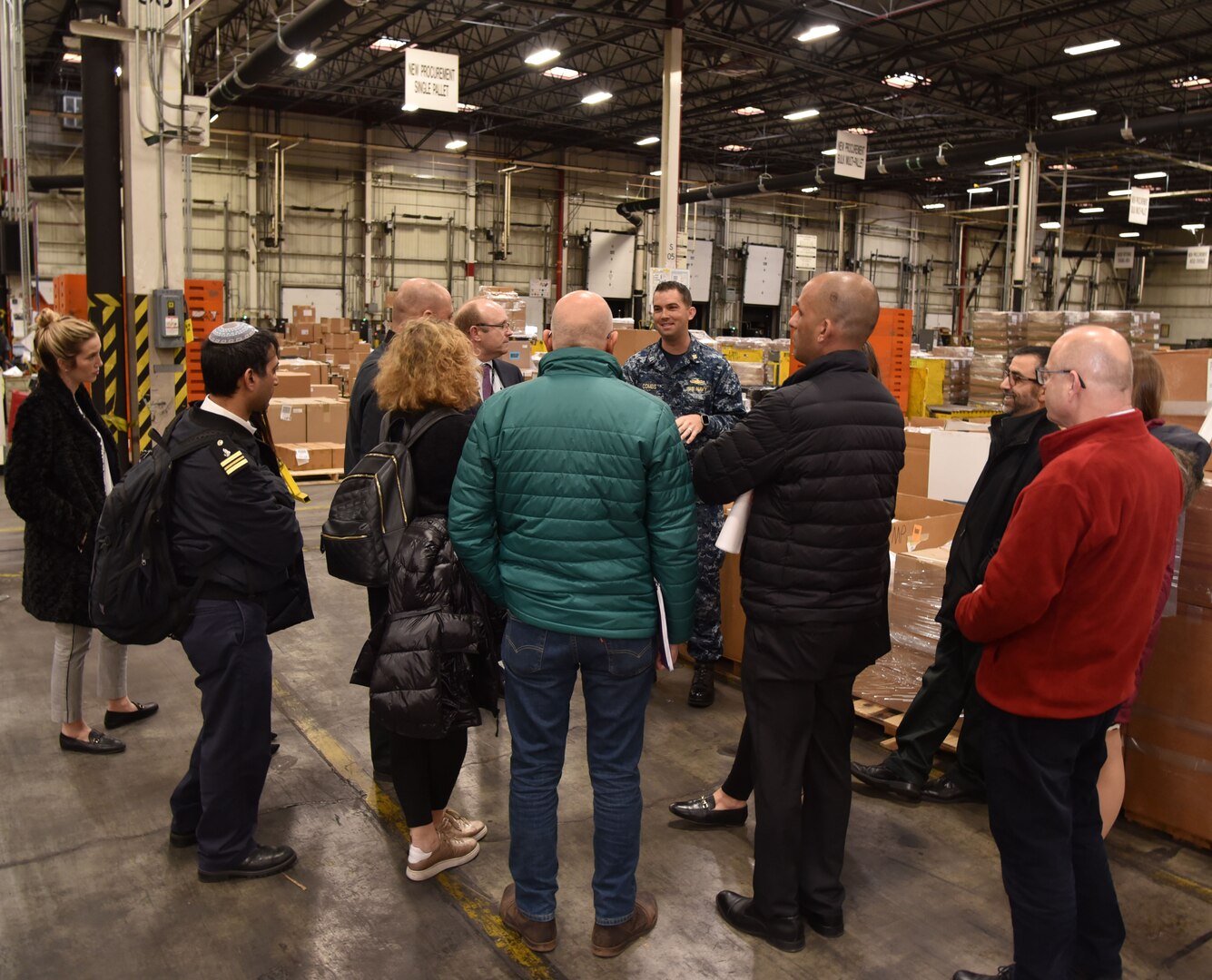 Navy LT Kyle Combs, operations officer, DLA Distribution Management Division, answers questions while the Israel Security Assistance Liaison Officers receive a tour through the DLA Eastern Distribution Center.