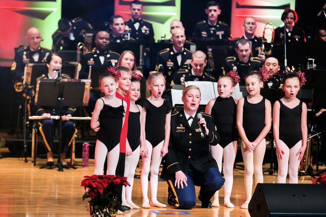 Army Sgt. Amy Mahoney sings with children from the Soles Sidekicks ballet dancers.