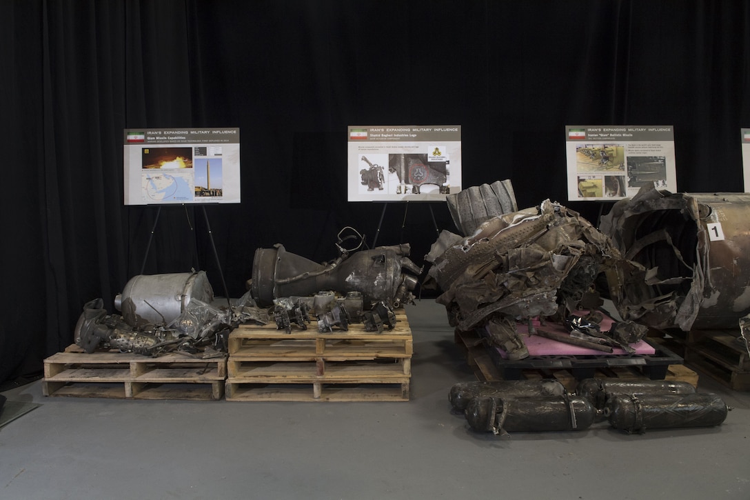 A signed display shows mangled metal remnants on crates.