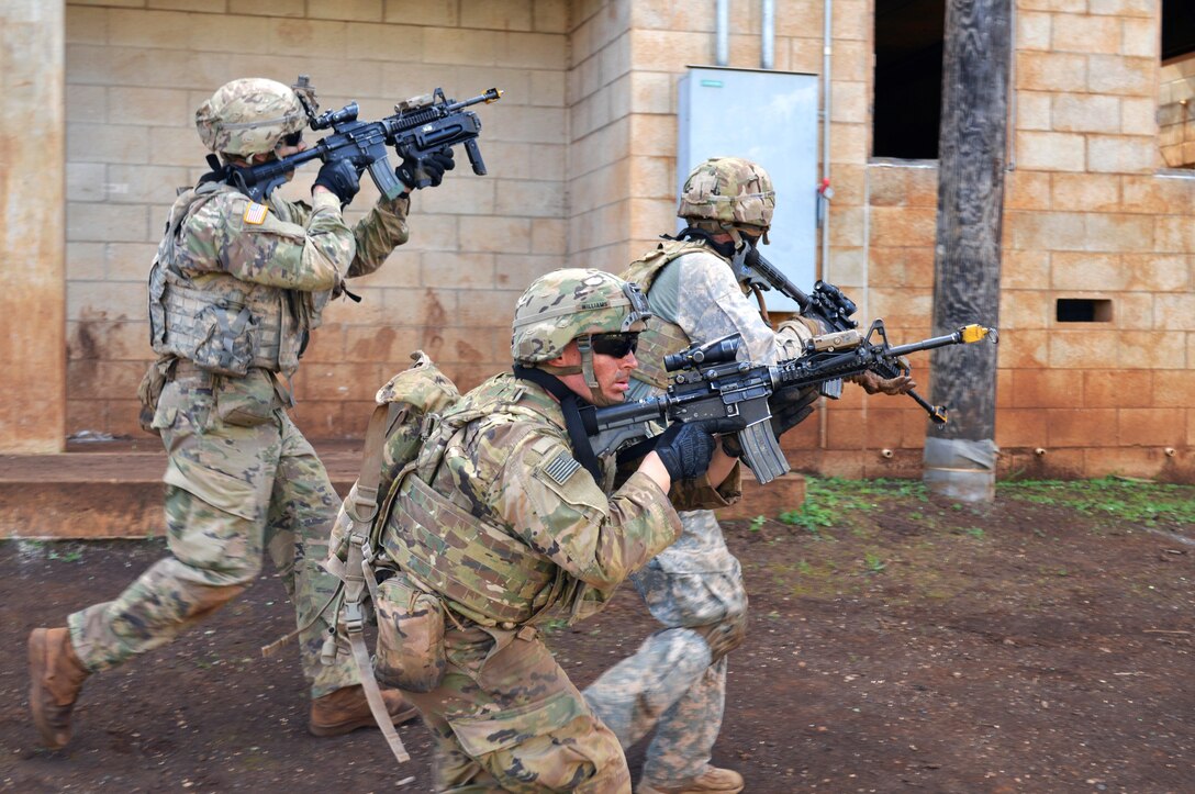 Three soldiers move through an area with firearms.