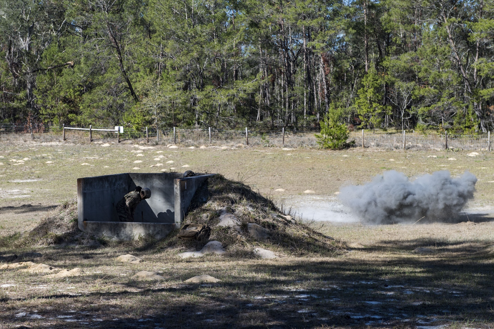 Tech. Sgt. Leticia Brazil, 823d Base Defense Squadron NCO in charge of medical, ducks for cover as grenade explodes during a heavy weapons qualification, Dec. 13, 2017, at Camp Blanding Joint Training Center, Fla. Airmen threw grenades targets to maintain their proficiency and familiarize themselves with the weapon. (U.S. Air Force photo by Senior Airman Janiqua P. Robinson)