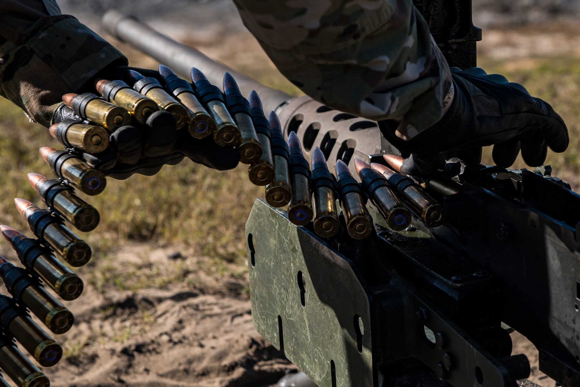 An Airman from the 823d Base Defense Squadron, loads a .50 Caliber M2 machine gun during a heavy weapons qualification, Dec. 13, 2017, at Camp Blanding Joint Training Center, Fla. Airmen shot at targets with the M2 to maintain their proficiency and familiarize themselves with the weapon. (U.S. Air Force photo by Senior Airman Janiqua P. Robinson)