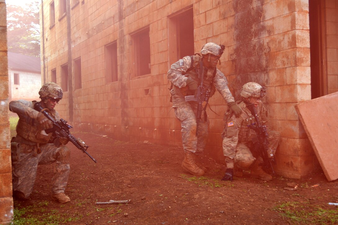 Three soldiers move through colored smoke.