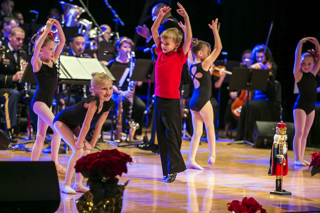 Children dance in front of Army musicians.