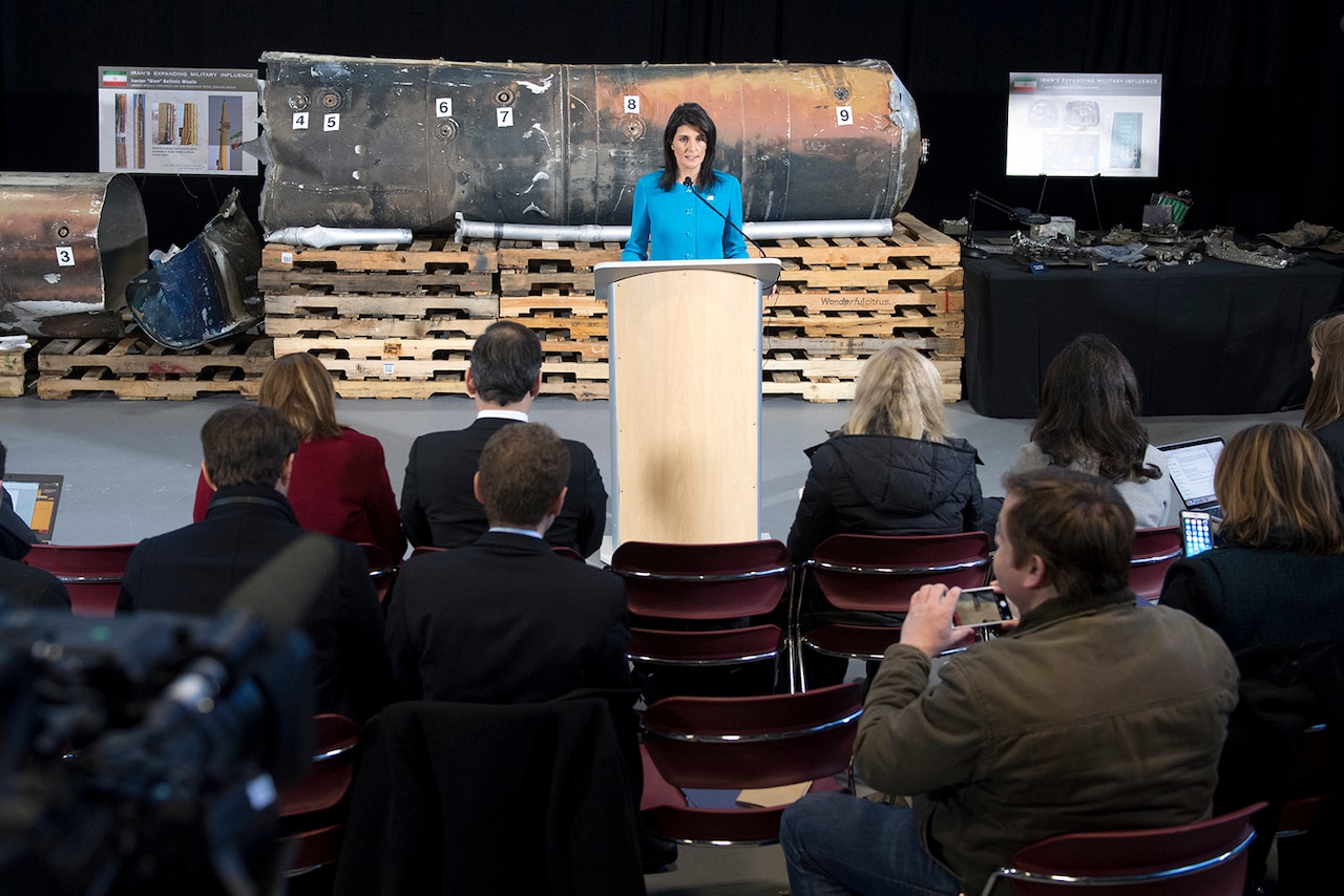 The U.S. ambassador to the United Nations stands in front of evidence during a news conference.