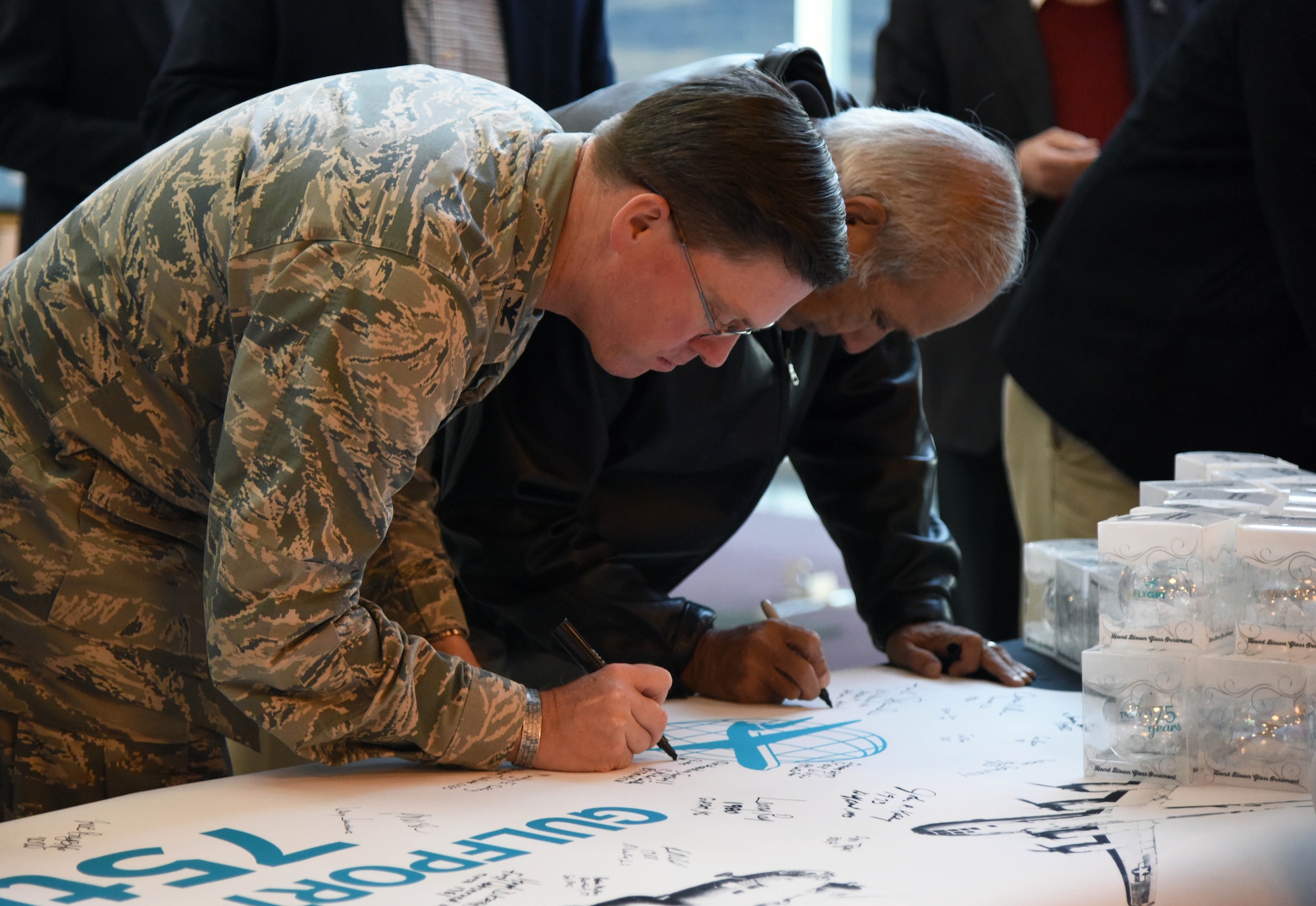 Col. C. Mike Smith, 81st Training Wing vice commander, signs a banner during the Gulfport-Biloxi International Airport 75 Year Commemoration Dec. 13, in Gulfport, Mississippi. A historical marker at the entrance of the airport was unveiled by local dignitaries during the event honoring the airport’s ties to the military dating back to 1942. The U.S. Air Force Band of the West, Nightwatch, also performed during the event. (U.S. Air Force photo by Kemberly Groue)