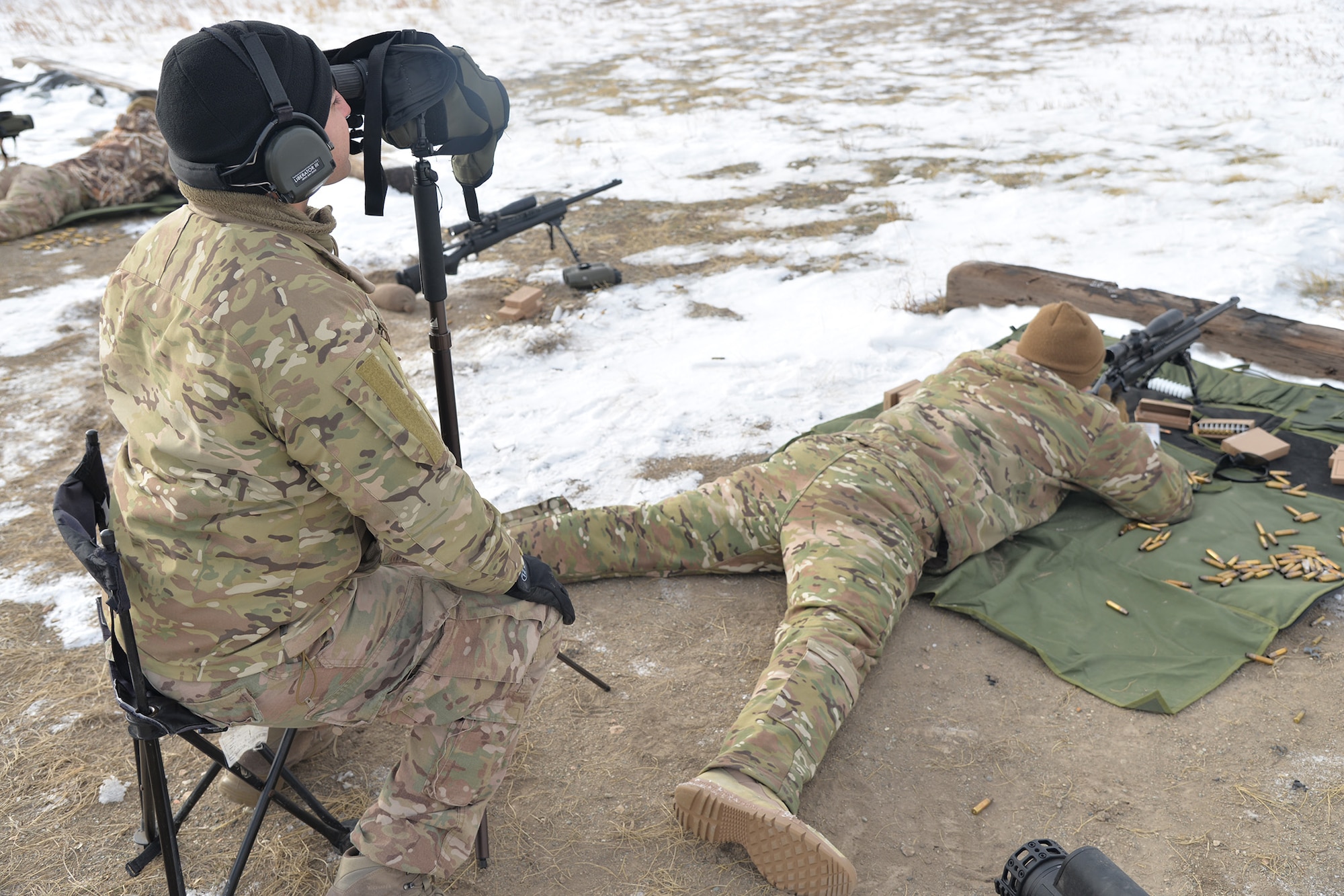 Senior Airman Richard Corpus-Munoz, 341st Security Support Squadron tactical response force nuclear advanced designated marksman flight trainer, left, spots for Airman 1st Class Keanu Valle, 341st SSPTS TRF NADM, while he fires a M24 sniper rifle Dec. 12, 2017, at Fort Harrison, Mont.