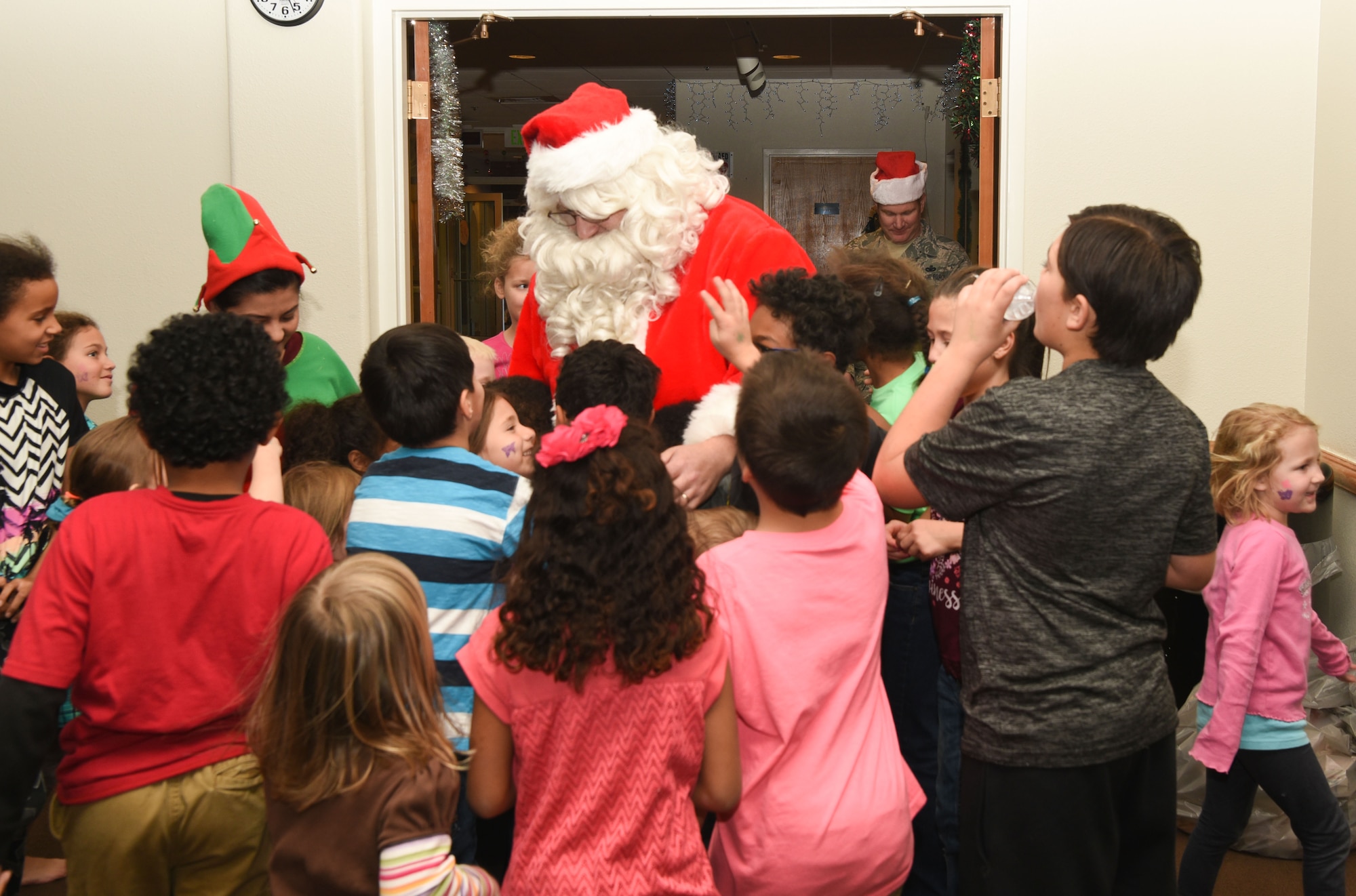 Children run to greet and hug Santa during Operation Provide Joy at F.E. Warren Air Force Base, on Dec. 9, 2017. Santa snuck into the building with his elf while the children were making crafts and playing in the bounce house. The event was established to booster community partnership and help local families in need get their children into the holiday spirit. (U.S. Air Force photo by Airman 1st Class Abbigayle Wagner)