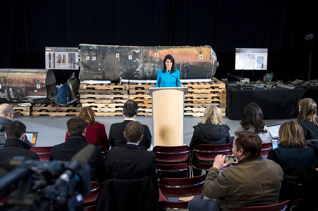 The U.S. ambassador to the United Nations stands in front of evidence during a news conference.