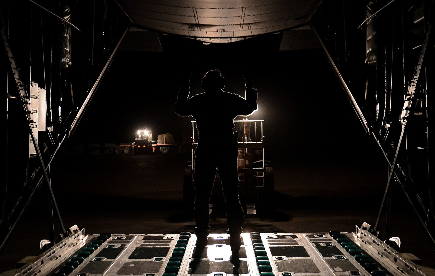 Airman 1st Class Courtney Wagner, 774th Expeditionary Airlift Squadron loadmaster, marshals a forklift onto a C-130J Super Hercules Dec. 9, 2017 at Bagram Airfield, Afghanistan.
