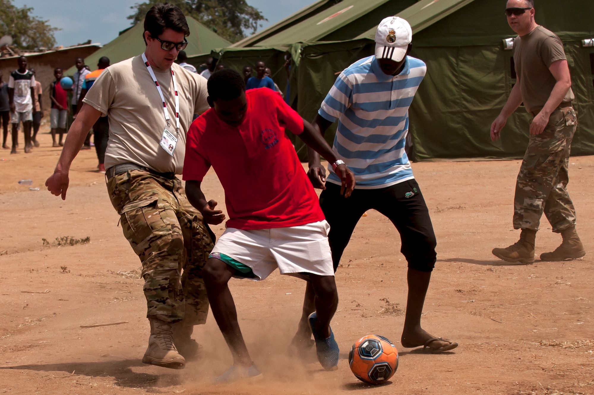 Members of the Ohio National Guard play soccer with children in the village of Vale do Paraiso during the PAMBALA 2017 medical exercise Dec. 12, 2017, in Bengo Province, Angola. The purpose of the engagement for the Ohio National Guard is to give personnel the opportunity to share best practices, strengthen medical treatment processes, establish new relationships with members of the Angolan Armed Forces and to nurture their existing 11-year partnership with Serbia, through the National Guard State Partnership Program. (Ohio National Guard photo by Staff Sgt. Wendy Kuhn)