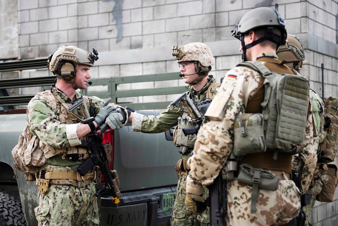 U.S. sailor speak with a German sailor.