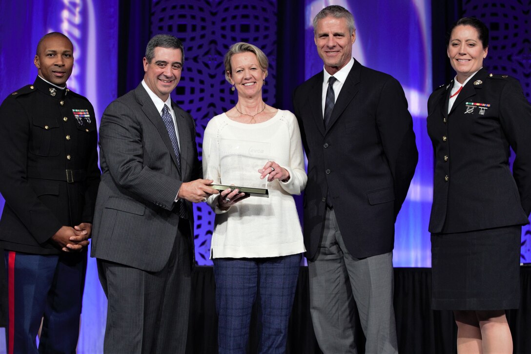 Mary Wise, head women's volleyball coach at the University of Florida, poses for a photo after receiving the U.S. Marine Corps American Volleyball Coaches Association (AVCA) National Coach of the Year Award, in Kansas City, Missouri, Dec. 14, 2017. Marine Corps Recruiting Command partners with the AVCA, teaching coaches about the aspirational career opportunities available to elite athletes in the Marine Corps. Wise and the Florida Gators are vying for a national championship in the 2017 NCAA volleyball tournament. (U.S. Marine Corps photo by Sgt. Nathan Wicks)