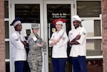 From left to right, Airman 1st Class Mrqkze Macon, Airman 1st Class Shelby Carson, Tech. Sgt. Jessica Ancheta, and Senior Airman Demarcus Johnson, all Airmen assigned to the 509th Force Support Squadron, stand outside of the "Touch & Go" kitchen on the flightline at Whiteman Air Force Base, Mo., Dec. 11, 2017.