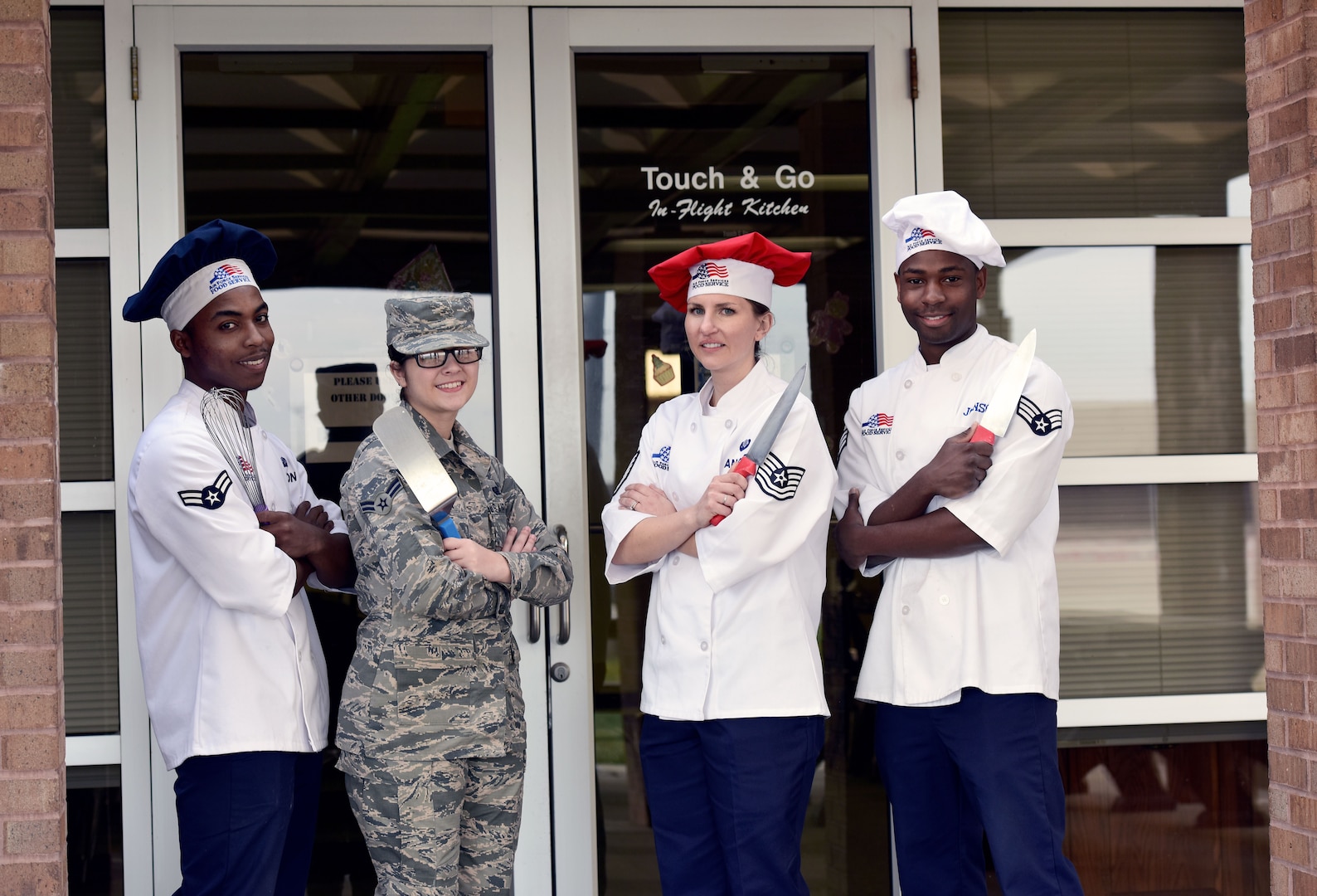 From left to right, Airman 1st Class Mrqkze Macon, Airman 1st Class Shelby Carson, Tech. Sgt. Jessica Ancheta, and Senior Airman Demarcus Johnson, all Airmen assigned to the 509th Force Support Squadron, stand outside of the "Touch & Go" kitchen on the flightline at Whiteman Air Force Base, Mo., Dec. 11, 2017.