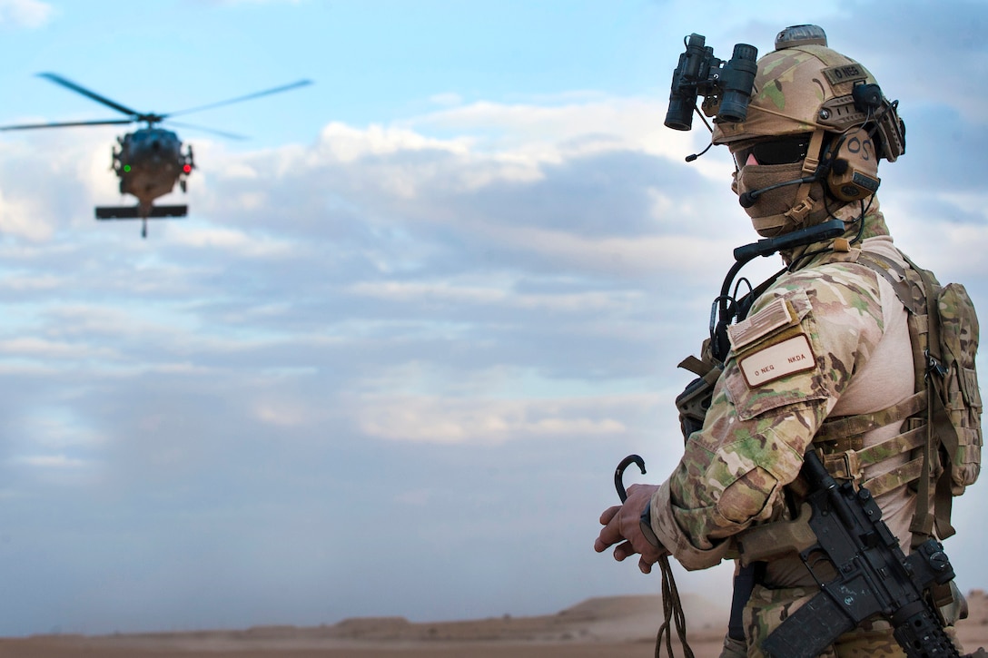An airman watches a helicopter approach.