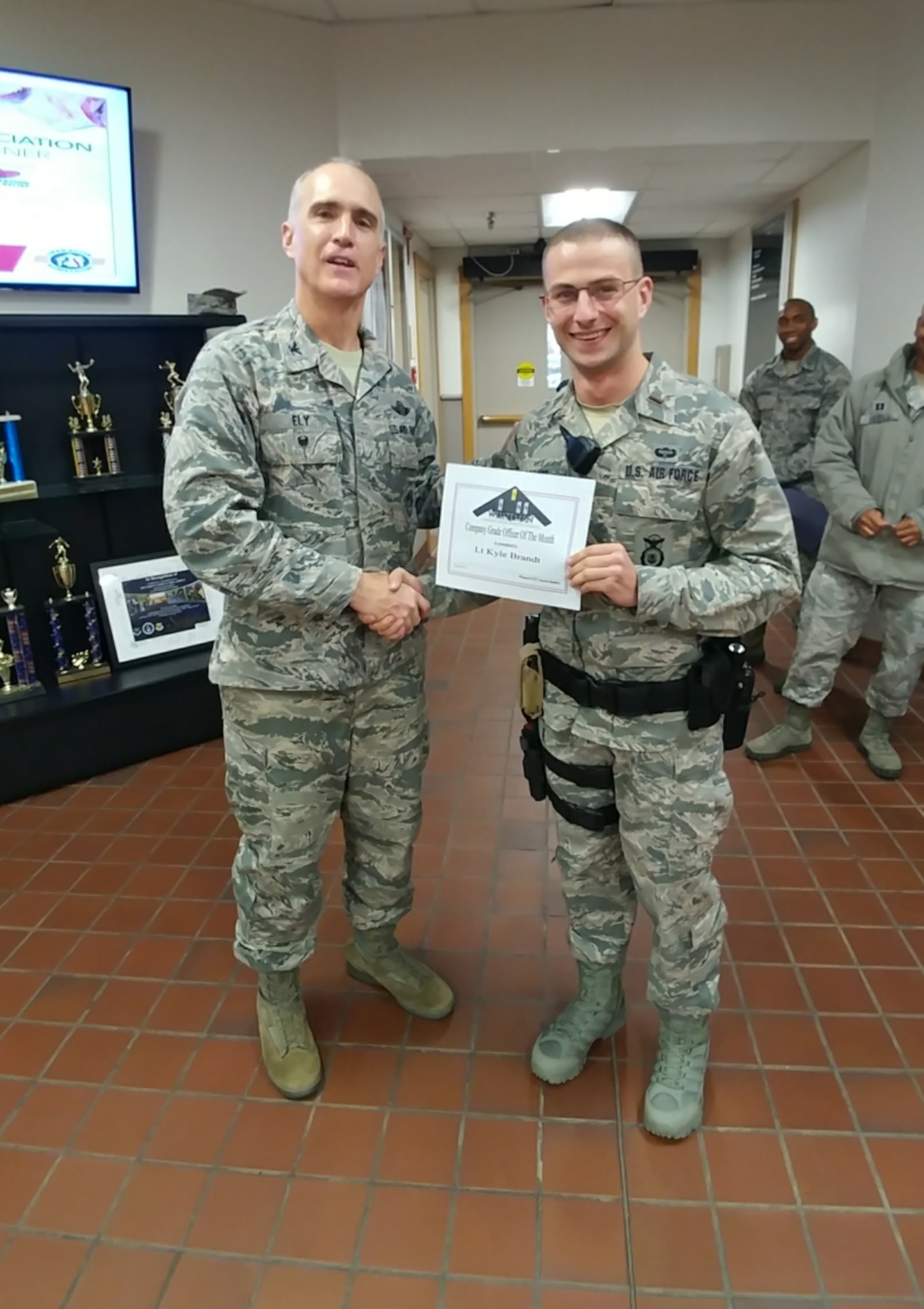 U.S. Air Force 2nd Lt. Kyle Brandt, the alpha flight commander assigned to the 509th Security Forces Sqaudron, right, receives a Whiteman Company Grade Officer Council (CGOC) Bars and Stars award for the month of August from Col. Mark Ely, the 509th Bomb Wing vice commander, at Whiteman Air Force Base, Mo., Dec. 13,  2017.