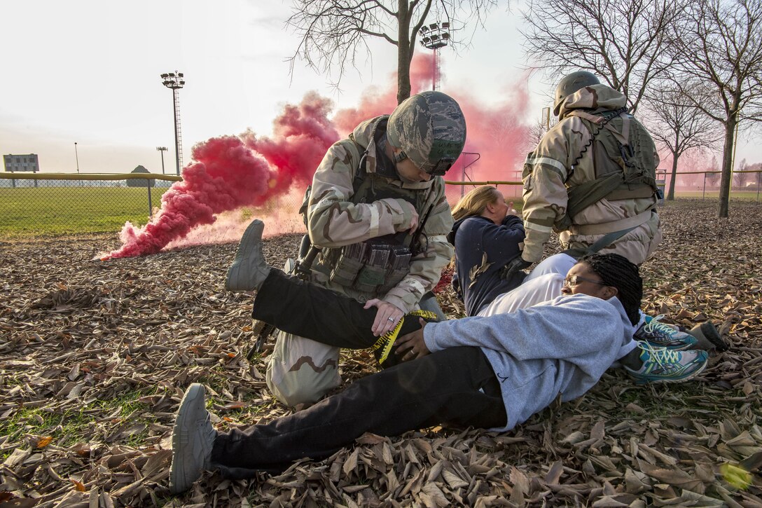 Airmen practice helping people laying on the ground.