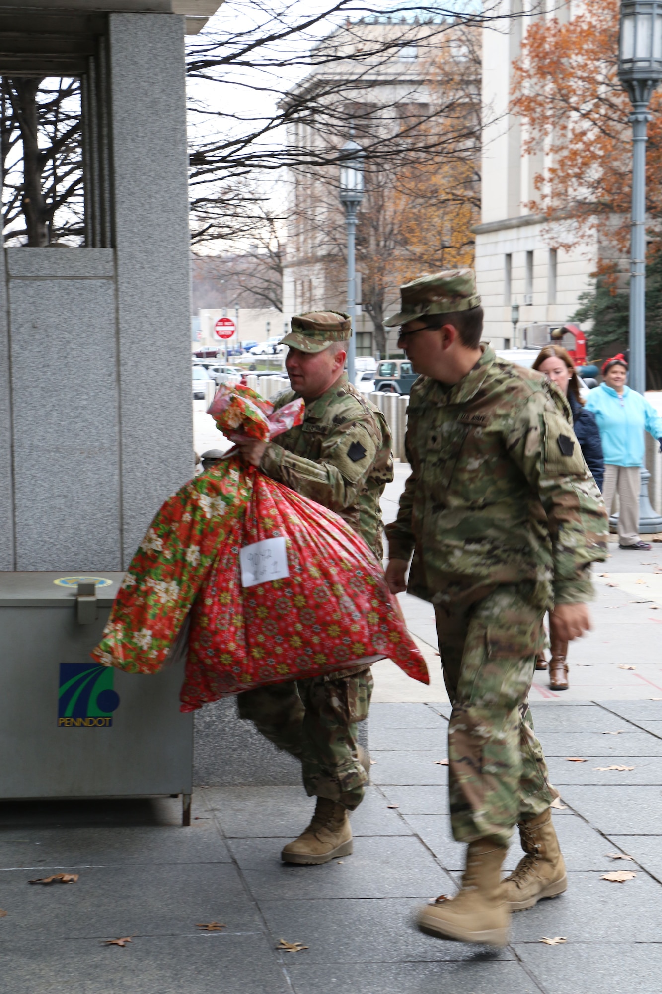 During the 2017 Holiday Wish Program, 193rd Regional Support Group Airmen and Pennsylvania Army Guardsmen carry in donated gifts into the Keystone Building, Harrisburg, Pennsylvania, Dec. 6, 2017. After a ceremony, with the help of volunteer state employees, they loaded the gifts into military vehicles and delivered them to participating county assistance offices for distribution to families and individuals.  (U.S. Air National Guard photo by Master Sgt. Culeen Shaffer/Released)