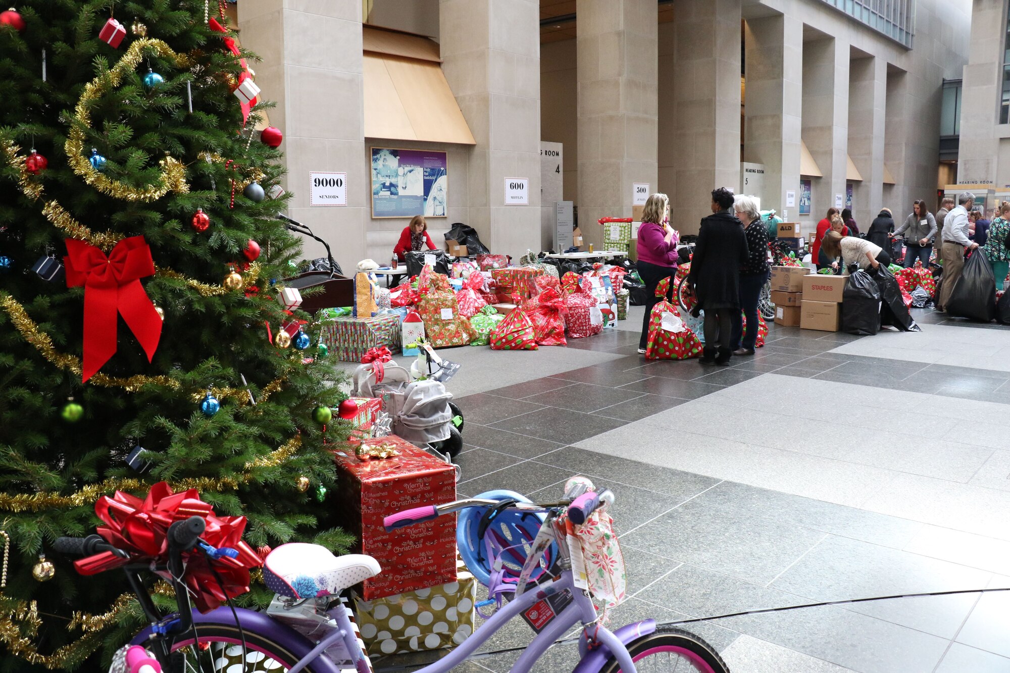 During the 2017 Holiday Wish Program, 193rd Regional Support Group Airmen and Pennsylvania Army Guardsmen carry in donated gifts into the Keystone Building, Harrisburg, Pennsylvania, Dec. 6, 2017. After a ceremony, with the help of volunteer state employees, they loaded the gifts into military vehicles and delivered them to participating county assistance offices for distribution to families and individuals.  (U.S. Air National Guard photo by Master Sgt. Culeen Shaffer/Released)