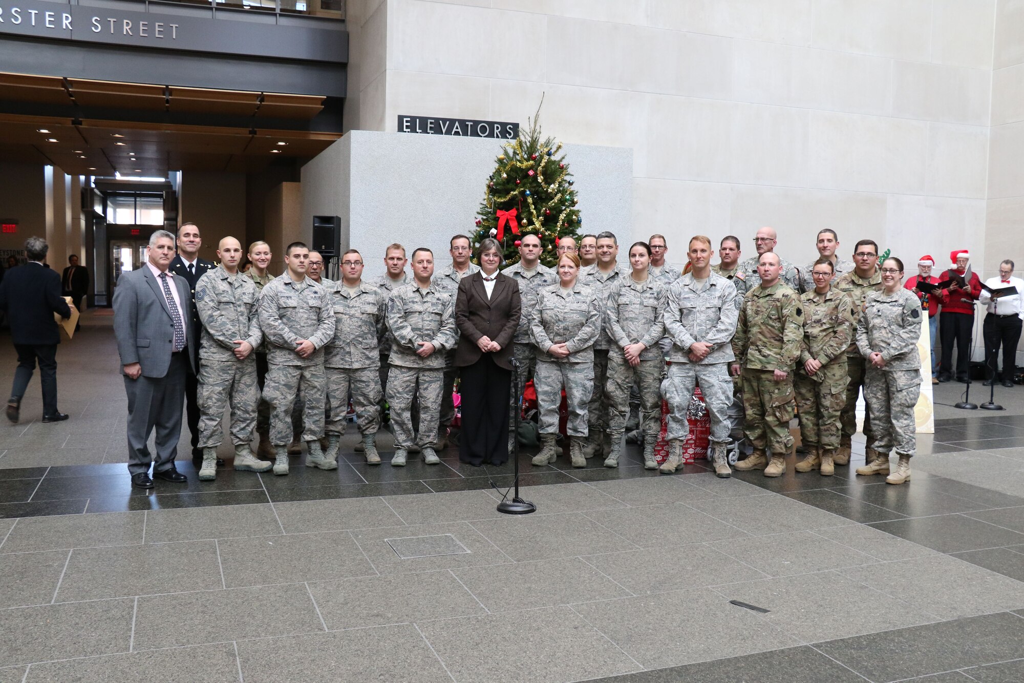 Before loading donated gifts into military vehicles, Pennsylvania National Guardsmen, pose for a group photo with First Lady Frances Wolf, Brig. Gen. David Wood and Gilbert “Dusty” Durand II, during the 28th annual Holiday Wish Program held at the Keystone Building, Harrisburg, Pennsylvania, Dec. 6, 2017. The Guardsmen delivered the gifts to participating county assistance offices for distribution to families and individuals.  (U.S. Air National Guard photo by Master Sgt. Culeen Shaffer/Released)