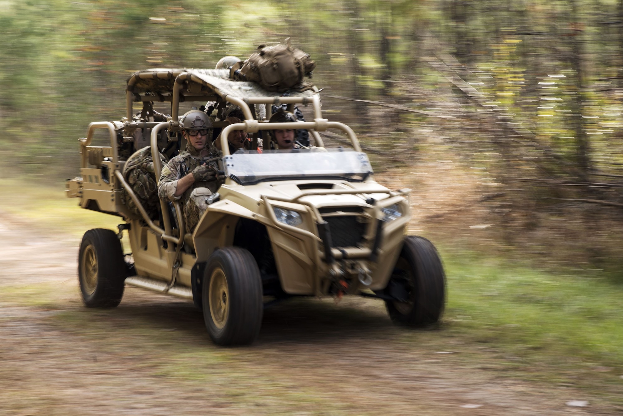 Airmen from the 38th Rescue Squadron (RQS)   drive a military RZR all-terrain vehicle during a full mission profile exercise, Dec. 14, 2017, at Moody Air Force Base, Ga. During the training, the 38th RQS recovered victims while under enemy fire to prepare for future search and rescue missions and to assess their unit’s ability to work cohesively to accomplish the mission. (U.S. Air Force photo by Airman Eugene Oliver)