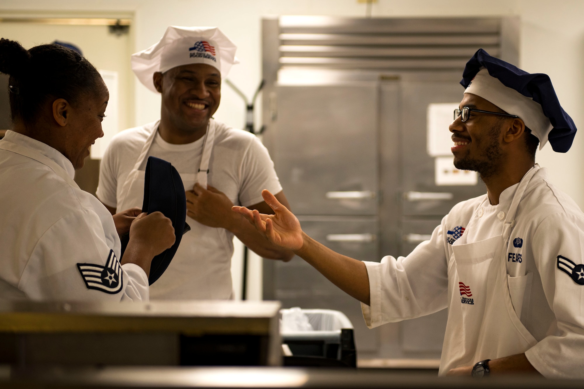 Staff Sgt. Latoya Wells, left, 23d Force Support Squadron (FSS) food services supervisor, Senior Airman Cameron Morrow, middle, 23d FSS food services journeyman, and Airman 1st Class Keven Fears, 23d FSS food services specialist, share a laugh in the Georgia Pines Dining Facility (DFAC), Dec. 12, 2017, at Moody Air Force Base, Ga. Through teamwork, adaption and striving for excellence, the Georgia Pines DFAC Airmen are able to ensure Team Moody is fed and ready to finish the fight. (U.S. Air Force Base photo by Airman 1st Class Erick Requadt)