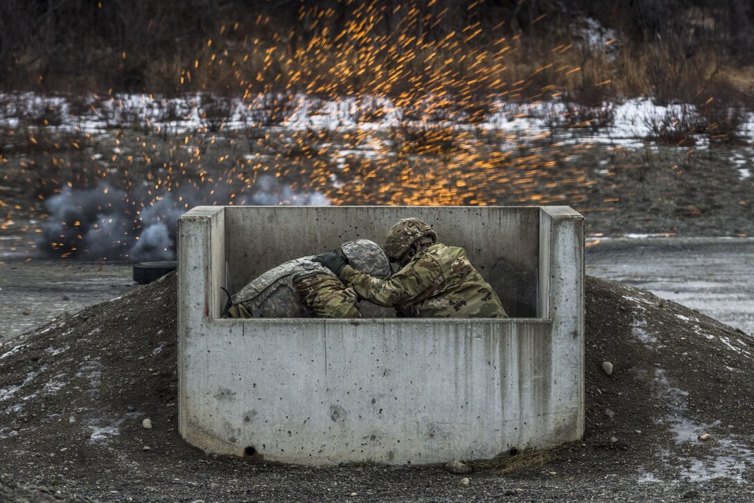 Soldiers hunker down behind cover as a grenade explodes.