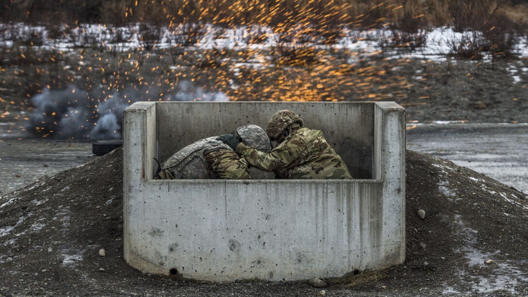 Soldiers hunker down behind cover as a grenade explodes.