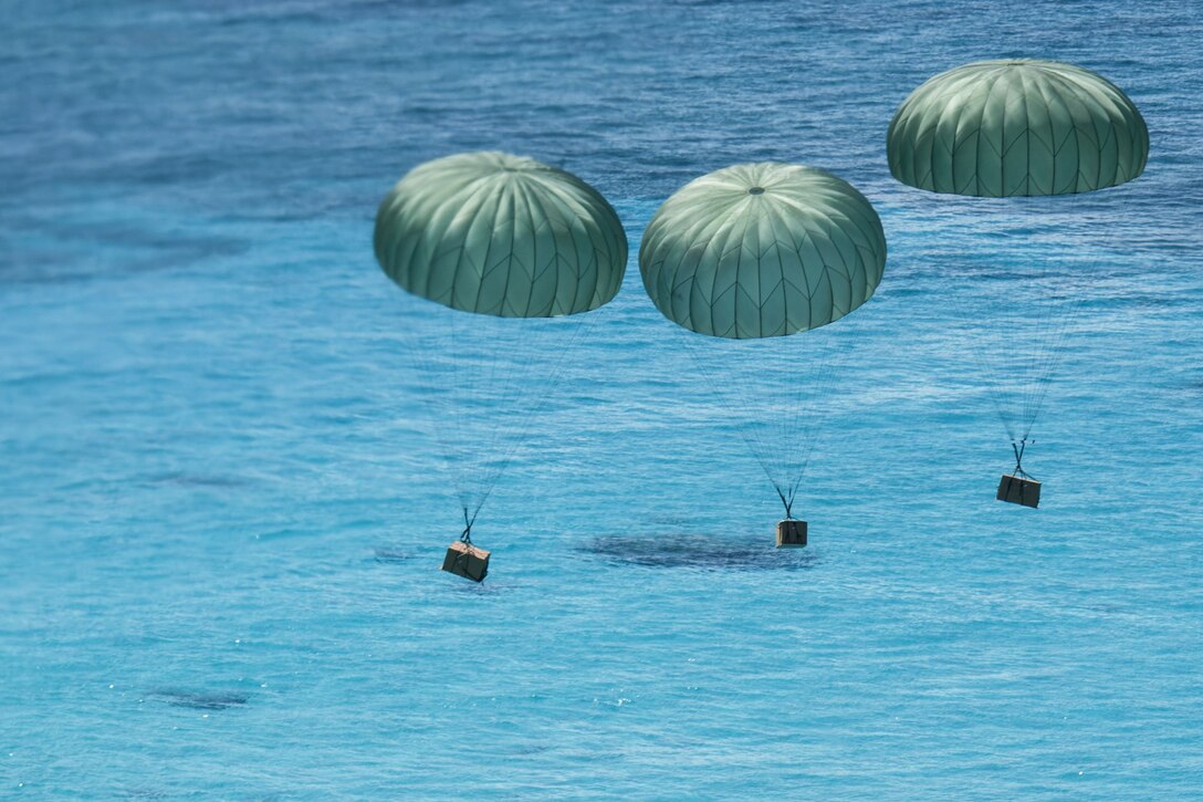 Three packages are parachuted to the ground.