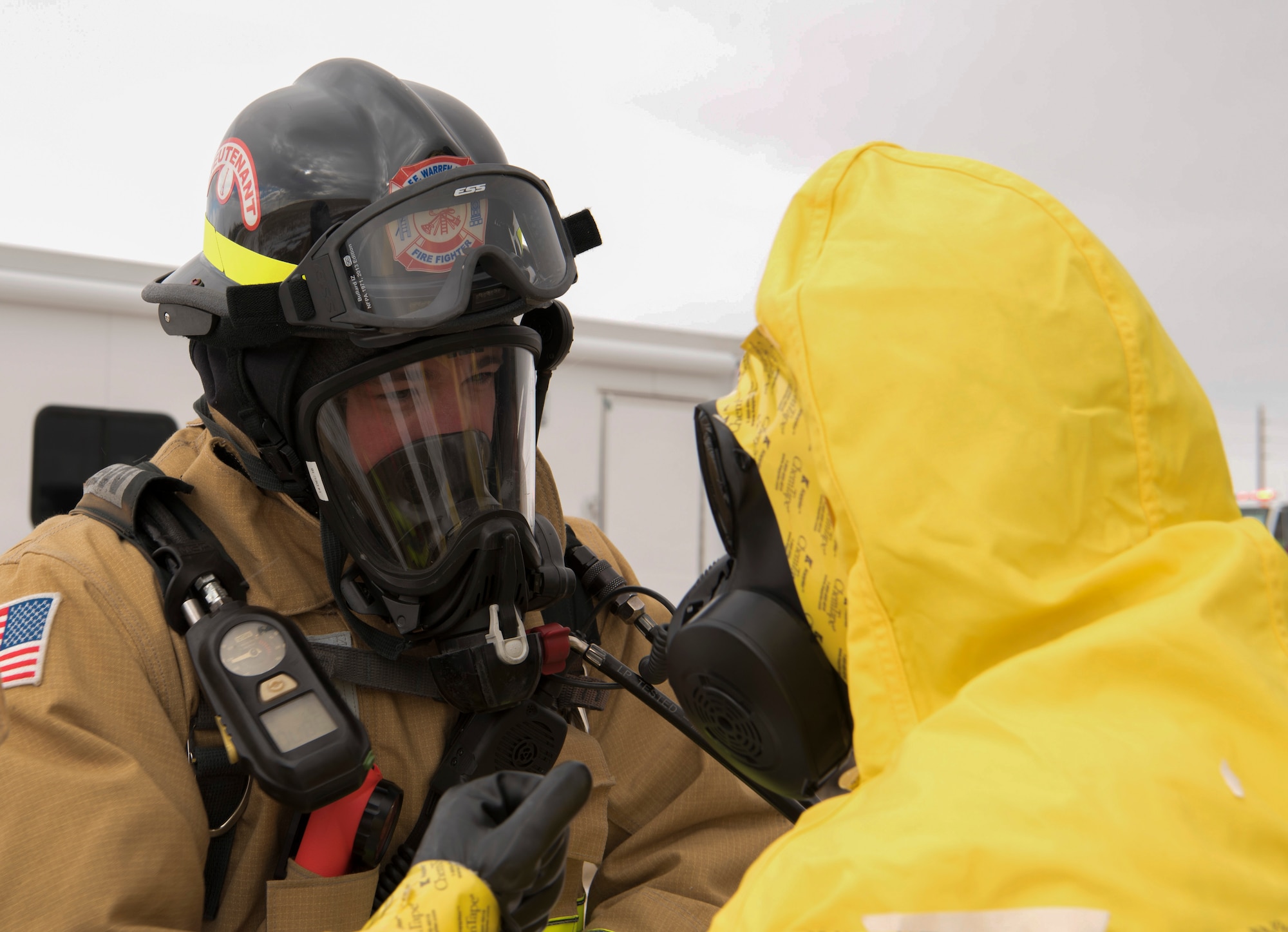Staff Sgt. Brandin McGovern, 90th Civil Engineering Squadron fire protection member, receives instructions from, an emergency management technician about the process of checking for radiological contamination during an exercise on F.E. Warren Air Force Base, Wyo., Dec. 14, 2017. Emergency management technicians check and remove the outer layer of protection gear to ensure there are no contaminates. (U.S. Air Force photo by Airman 1st Class Braydon Williams)