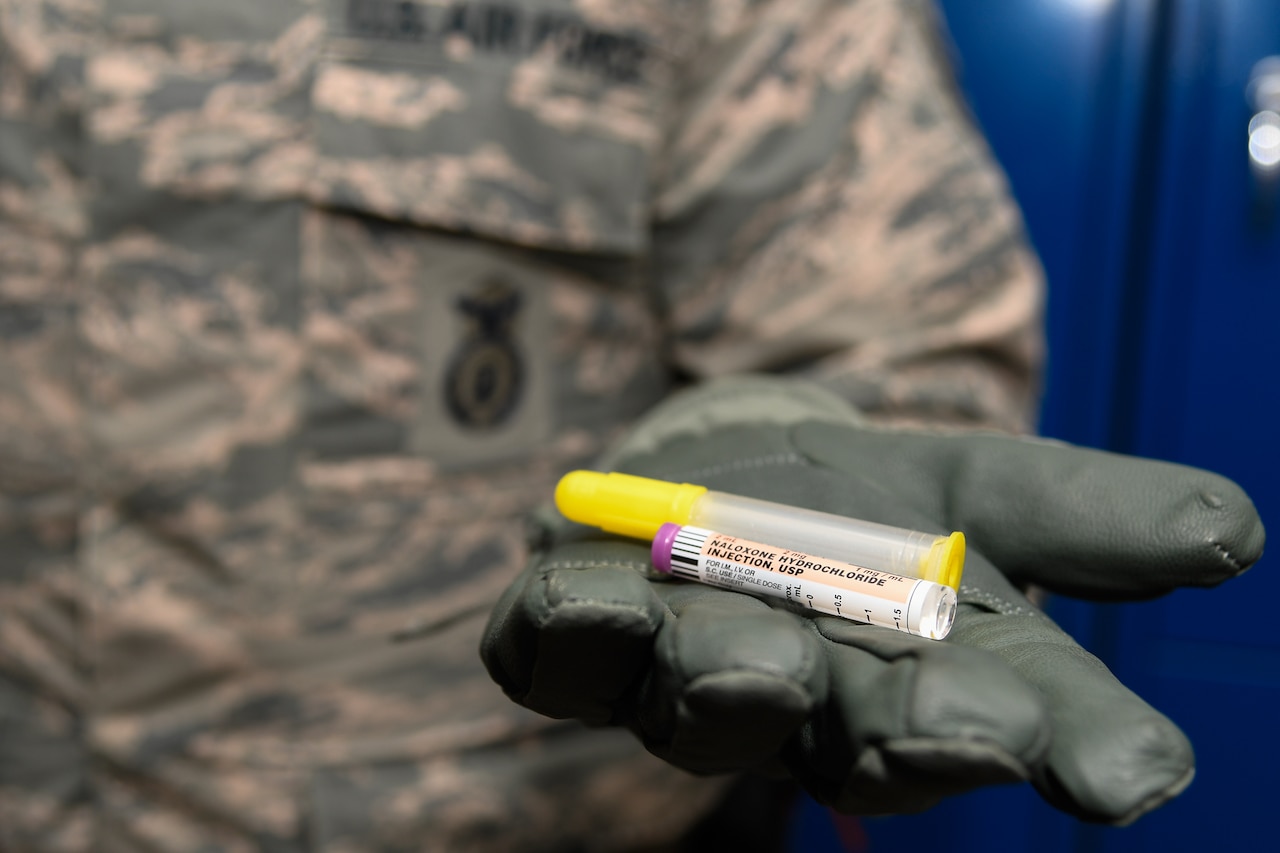 Staff Sergeant Matthew Pick, 66th Security Forces Squadron, holds a nasal applicator and naloxone medication vial.