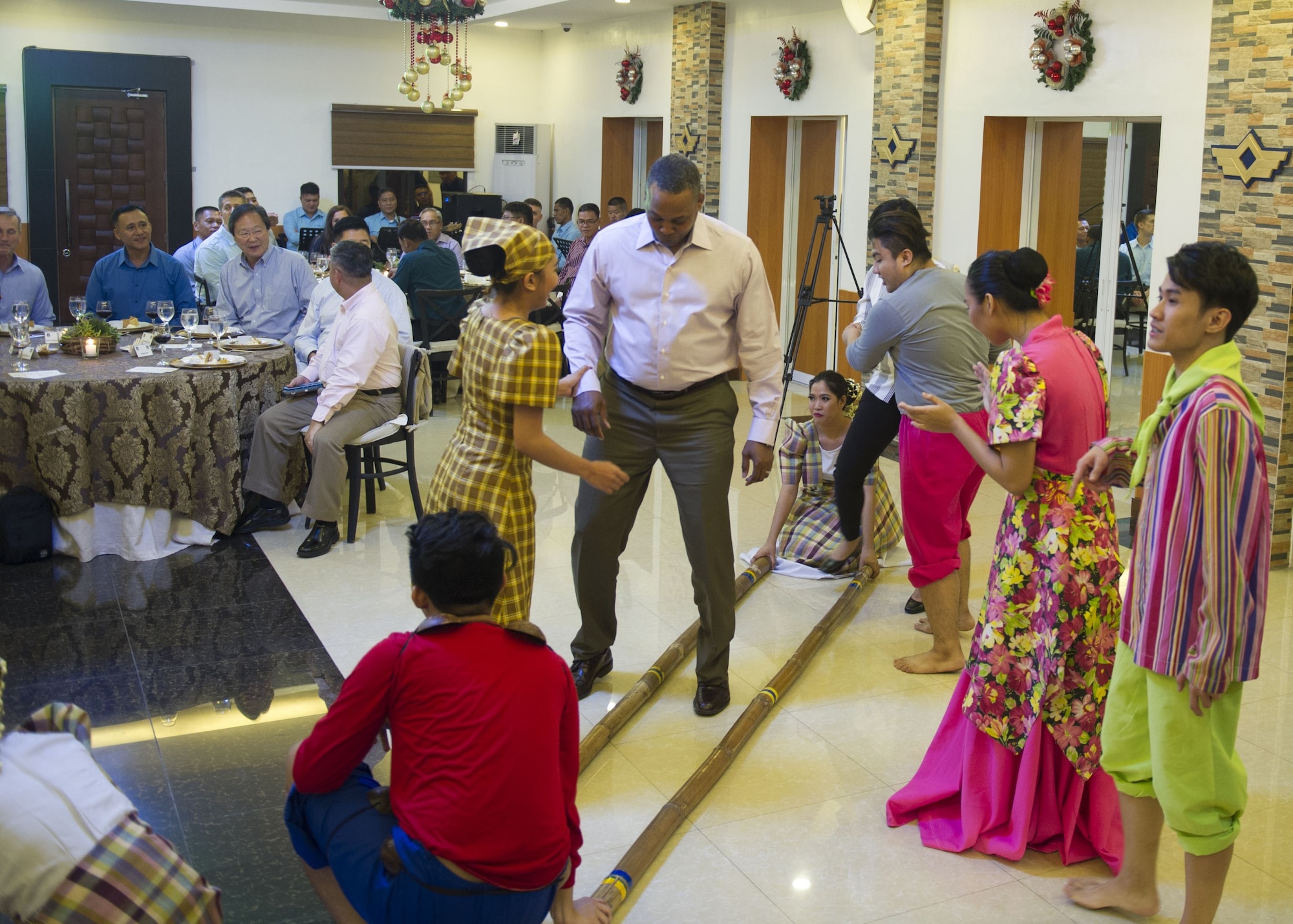 Chief Master Sgt. Anthony Johnson, Pacific Air Forces command chief, learns a traditional Filipino dance during a dinner hosted by the PAF, Manila, Philippines Dec. 11.