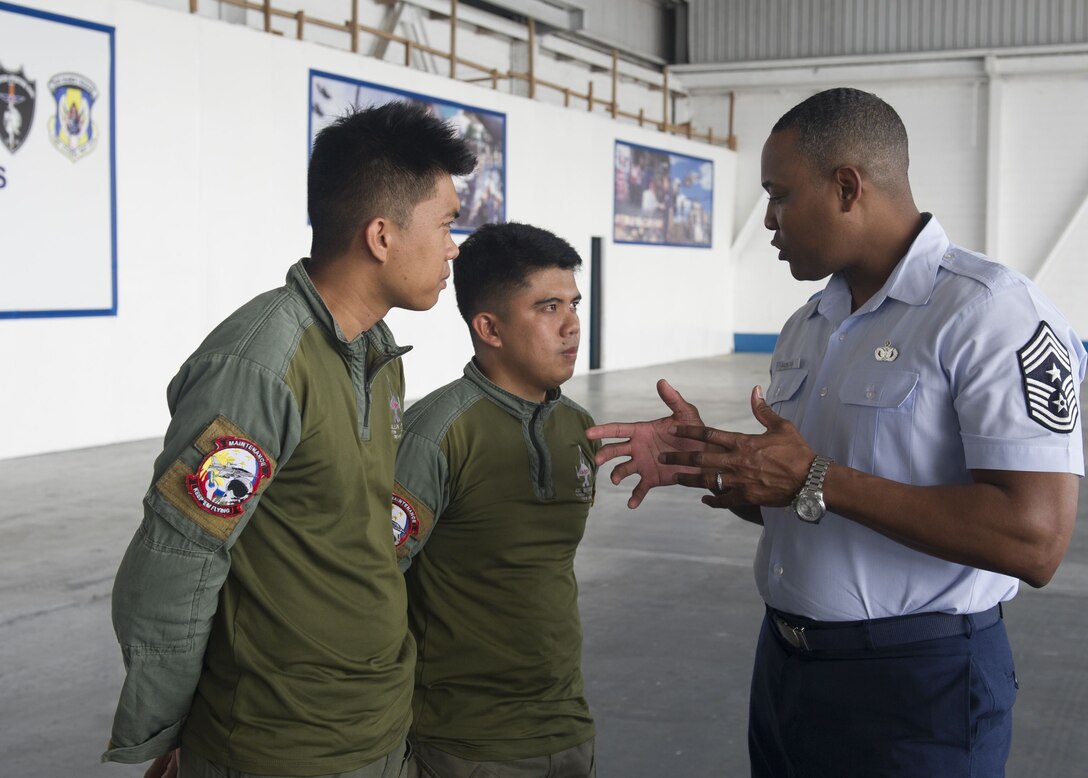Chief Master Sgt. Anthony Johnson, Pacific Air Forces command chief, speaks with Philippines Air Force crew chief during a visit to Clark Air Base, Philippines Dec. 12