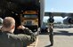 Staff Sgt. Paul Sizemore, 317th Airlift Squadron loadmaster at Joint Base Charleston, South Carolina, guides the offloading of school buses from a C-17 aircraft in Port-au-Prince, Haiti, Dec. 16, 2017. The buses are destined for a local school run by outreach organizations Those Angels Foundation and Sister Cities International, and were transported as part of the Denton program, which allows for space available on military aircraft to be used for humanitarian cargo. (U.S. Air Force photo by Capt. Justin Clark)